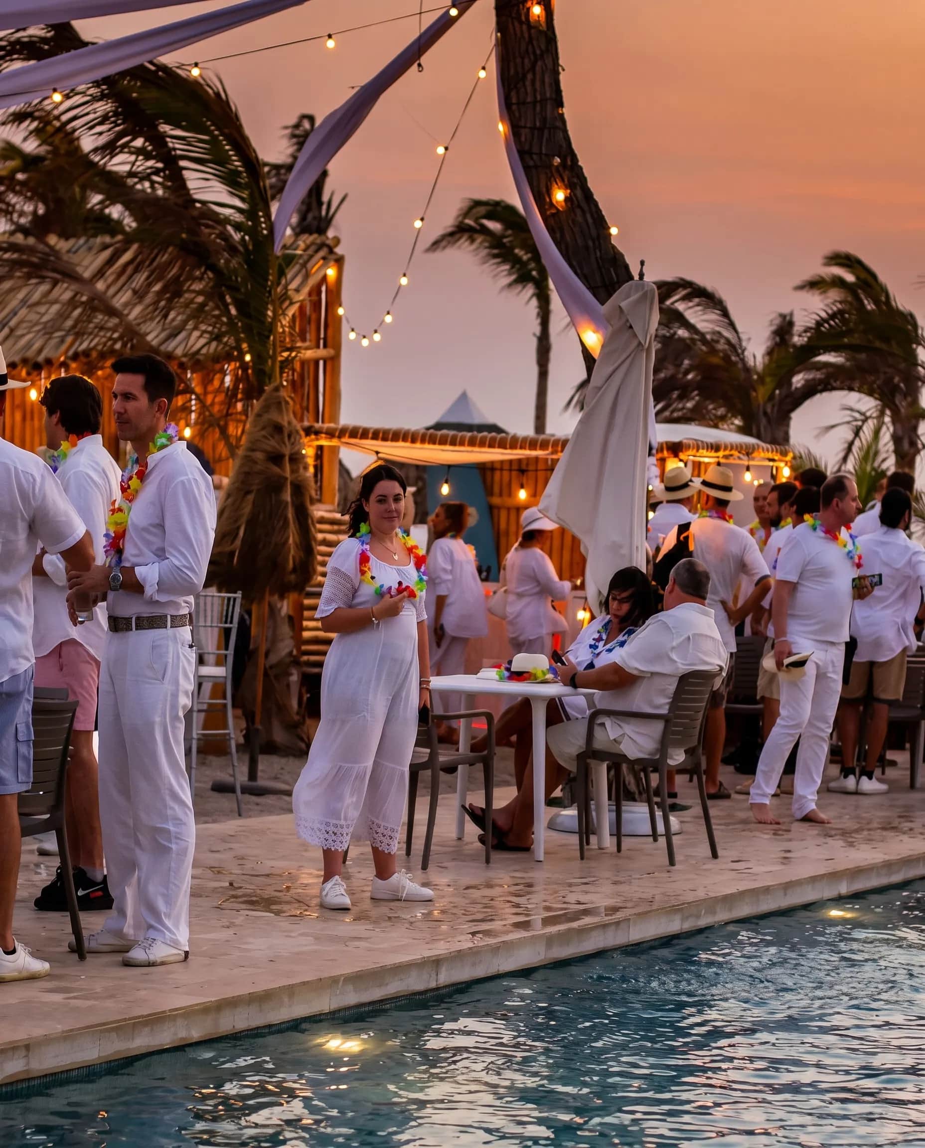 Fiesta de blanco junto a la piscina al atardecer